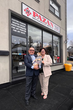 Marcelo and Gloria Pazan with Bruiser the Chihuahua pet in front of the Pazan Gallery and Picture Framing shop